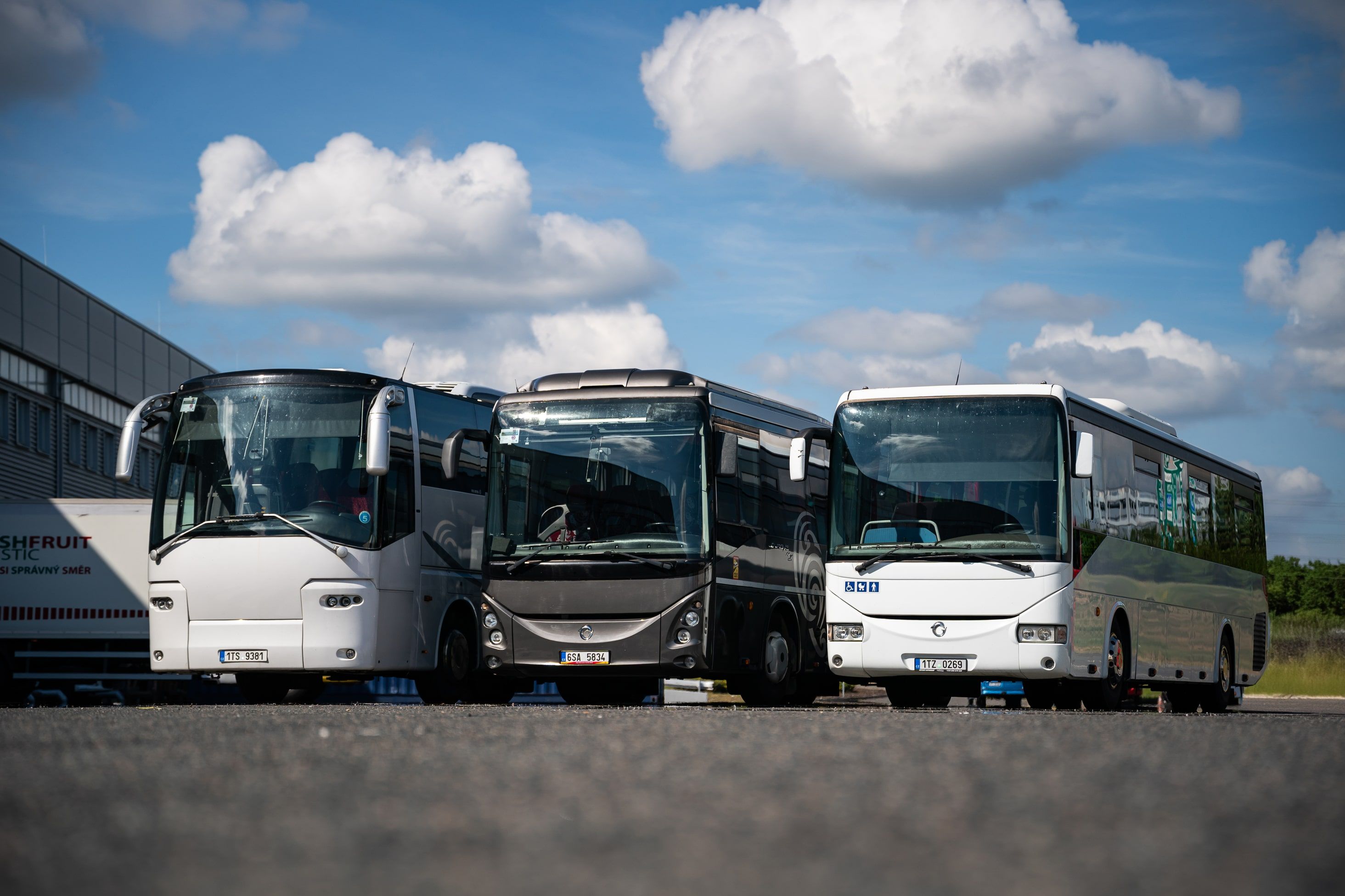 Skupina spokojených klientů před firemním minibusem.