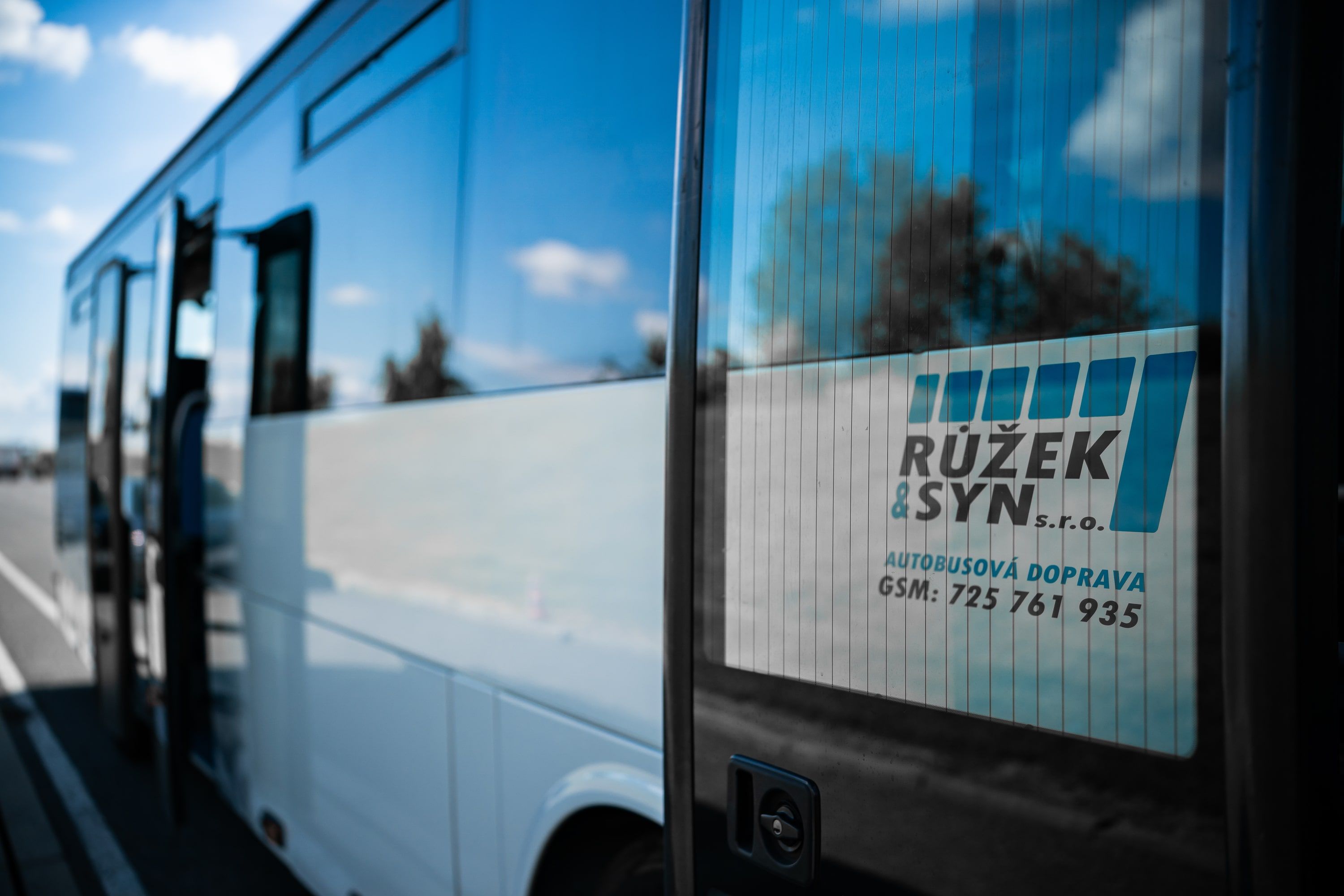 Řada autobusů parkovišti, připravených k přepravě.